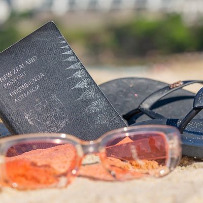 Passport, thongs and sunnies in the sand