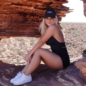 A girl sitting on red rock in the Outback