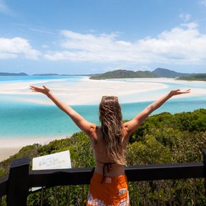 A woman standing at Hill Inlet Lookout on Whitsunday Island, admiring the view of Whitehaven Beach