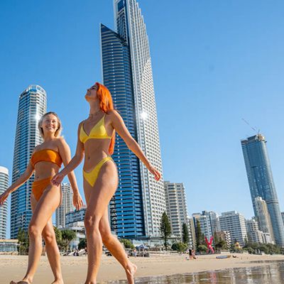 Two girls on the Gold Coast beach in colourful swimmers