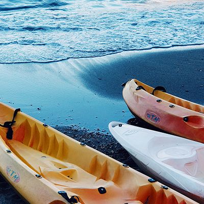 4 colourful kayaks on the sandy shore