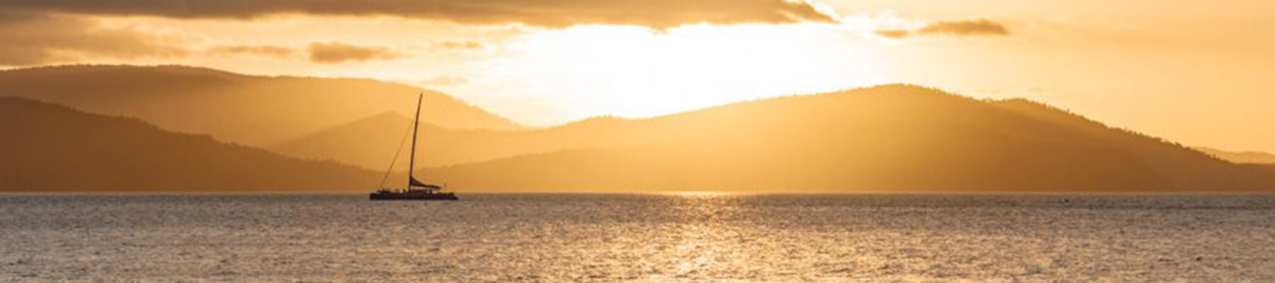 Island sunset whitsundays sailing boat in distance