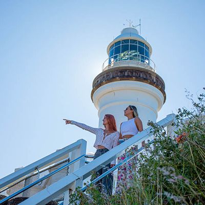 Girls at the Byron Bay lighthouse pointing at the view