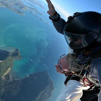 A woman with her skydive buddy in the sky over the Whitsunday Islands