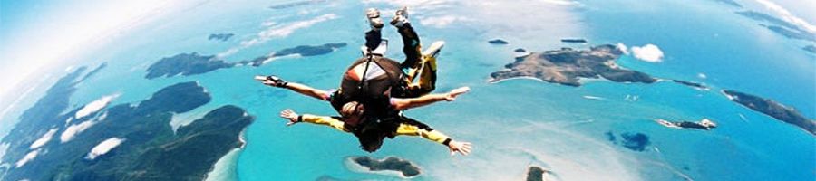 Two people tandem skydiving over the Great Barrier Reef