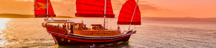 Shaolin Junk Boat at sunset with sails up