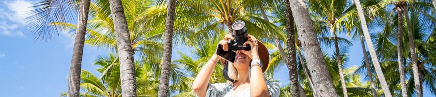 Women taking a photo of Cairns palm trees with a camera