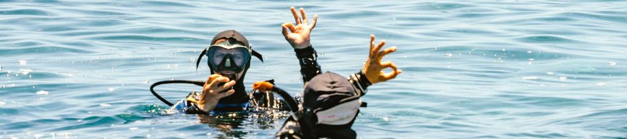 Two scuba divers making the 'okay' sign