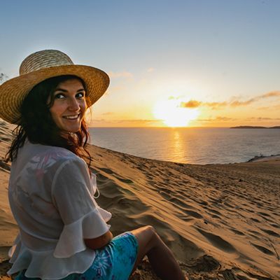 Woman looking at a sunset at the Rainbow Beach sandblow