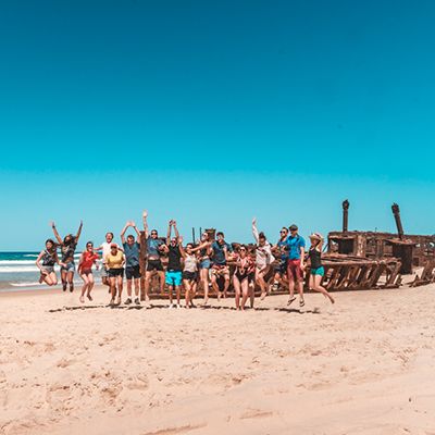 Group of young people in front of Maheno Shipwreck