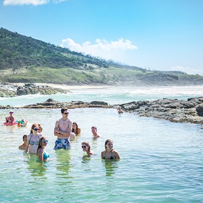 A group of backpackers swimming in the Champagne Pool rockpool