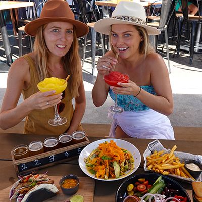 Cairns restaurants, two women eating food and sipping cocktails