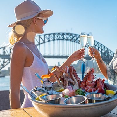 Woman looking at the Harbour bridge with a glass of champagne