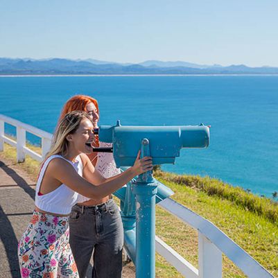 Two women using the binoculars at Byron Bay Lighthouse Lookout