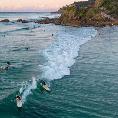 Surfers riding waves at The Pass beach, Byron Bay