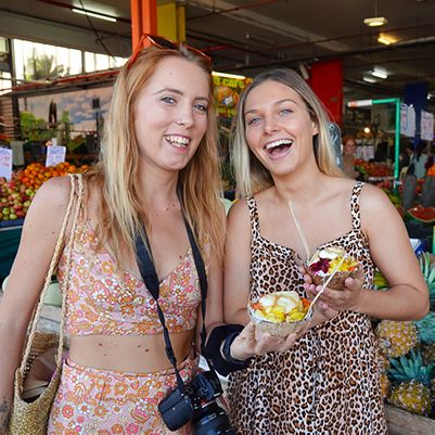 Two people holding acai bowls in Cairns