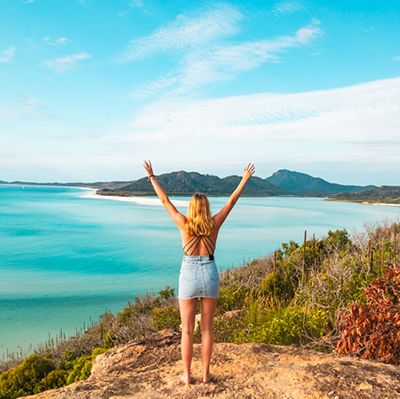 Woman with arms in the air overlooking Hill Inlet, Whitsundays