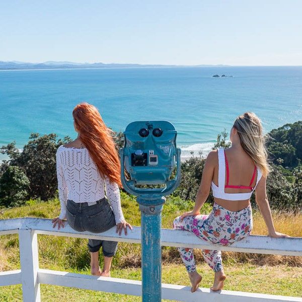 Two girls surveying Byron from cliff