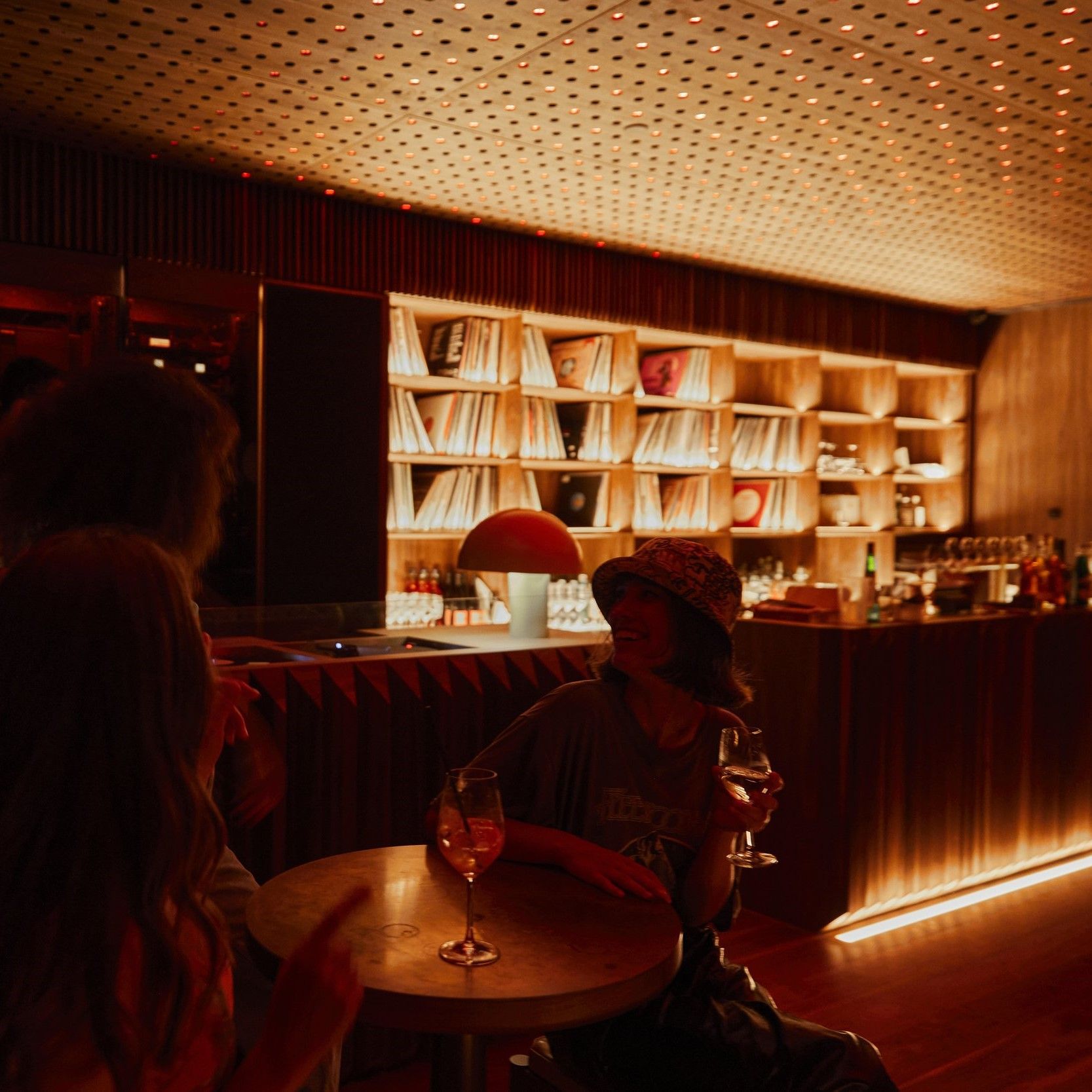 Girls drinking wine in dimly lit bar