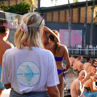 Woman in an East Coast Tours tshirt by the pool