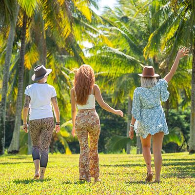 Three people walking through palm trees
