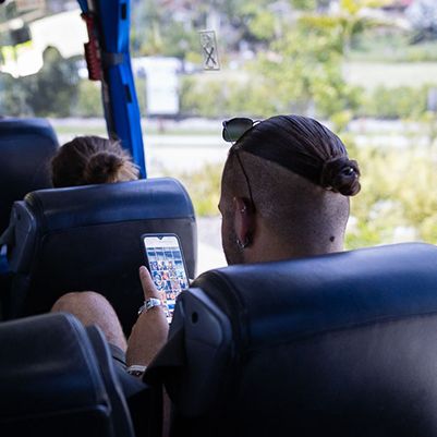 Man looking at his phone on a bus