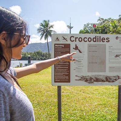 Woman pointing at a crocodile sign