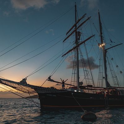 A sailing ship in the water at sunset
