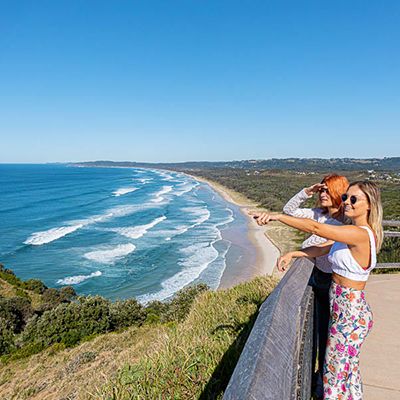 Two women on the coast of Byron Bay looking over the sea 