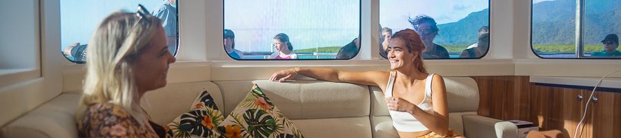 Two women sitting in the Gold Class lounge on Evolution Reef Cruise