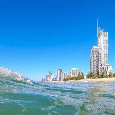 A view of cityscape on the horizon with waves in the foreground