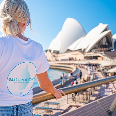 A woman with blonde hair in a white ECT tshirt at the Sydney Opera House