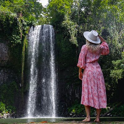 Woman in a pink dress looking at Millaa Millaa Falls