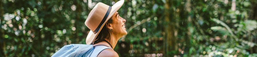 traveller with a hat and backpack admiring the daintree rainforest