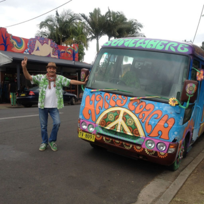 Tour guide giving peace sign standing next to bus