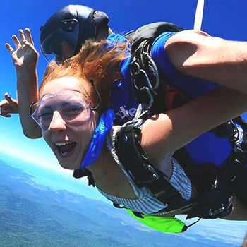 A woman skydiving over islands