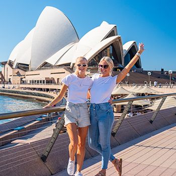 Two people in front of the Sydney Opera House with big smiles