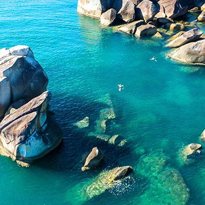 person swimming in the blue water at dunk island