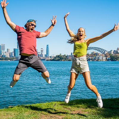 people jumping in front of Sydney Harbour