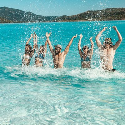 people splashing water around on Whitehaven Beach