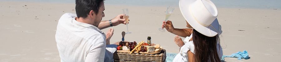 couple having a picnic with champagne on the beach