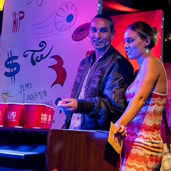 A couple at bar playing beer pong