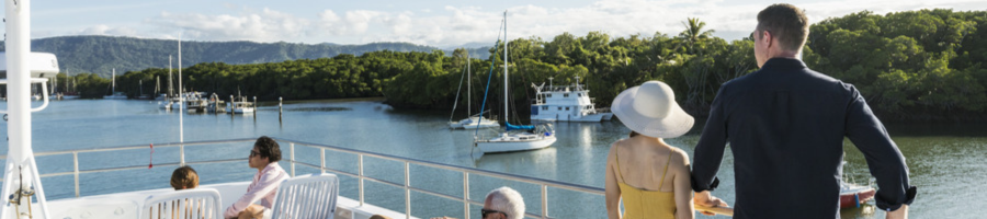 Couple standing on the top deck of Calypso vessel cruising to Low Isles