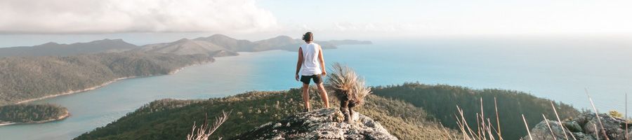 Man stood at the top of Whitsunday Cairn looking over the islands