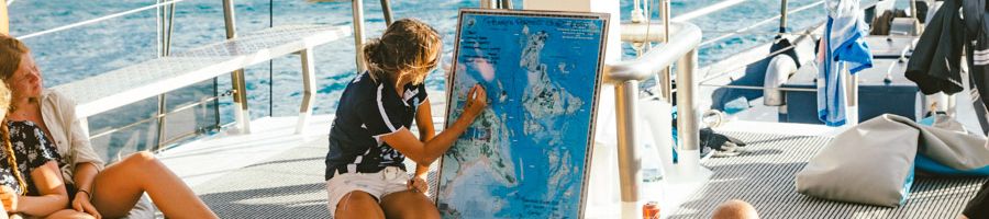 A crew member marking the navigational points on a map of the Whitsundays