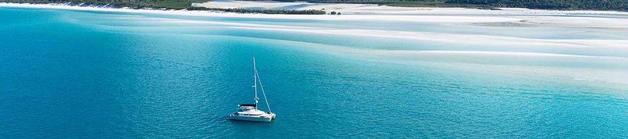 catamaran cruising past hill inlet lookout whitsundays