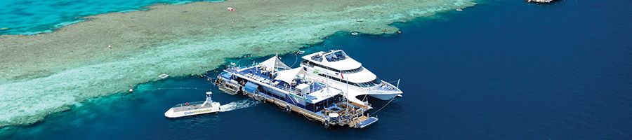 Pontoon and boat anchored next to Great Barrier Reef