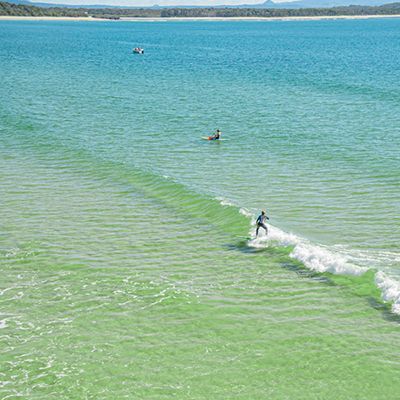 person surfing on blue water in Noosa