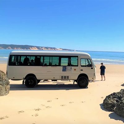 Epic Ocean Adventures 4WD Bus parked on the beach