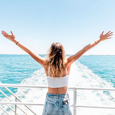 A woman with her arms out on a ferry